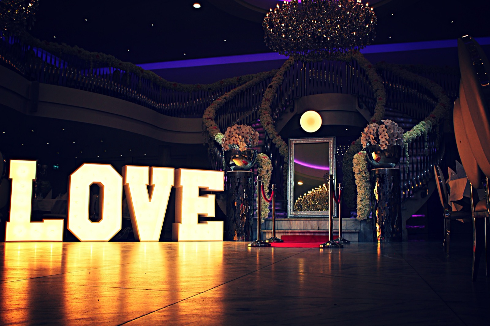 Grote oplichtende LOVE letters in een sfeervolle ballroom